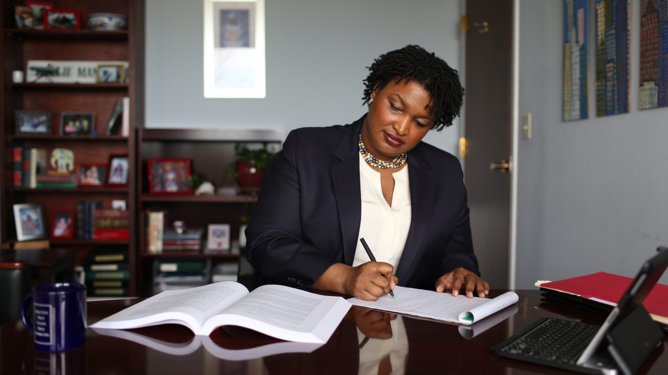 Photo of Stacey Abrams working at a desk.